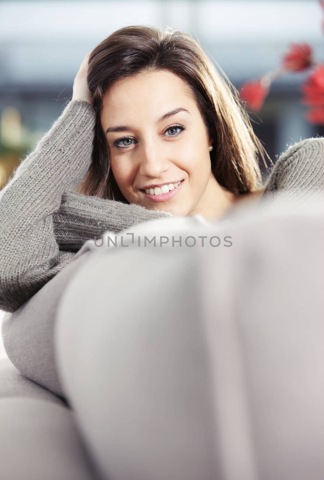 Portrait of a beautiful young woman on couch by stokkete