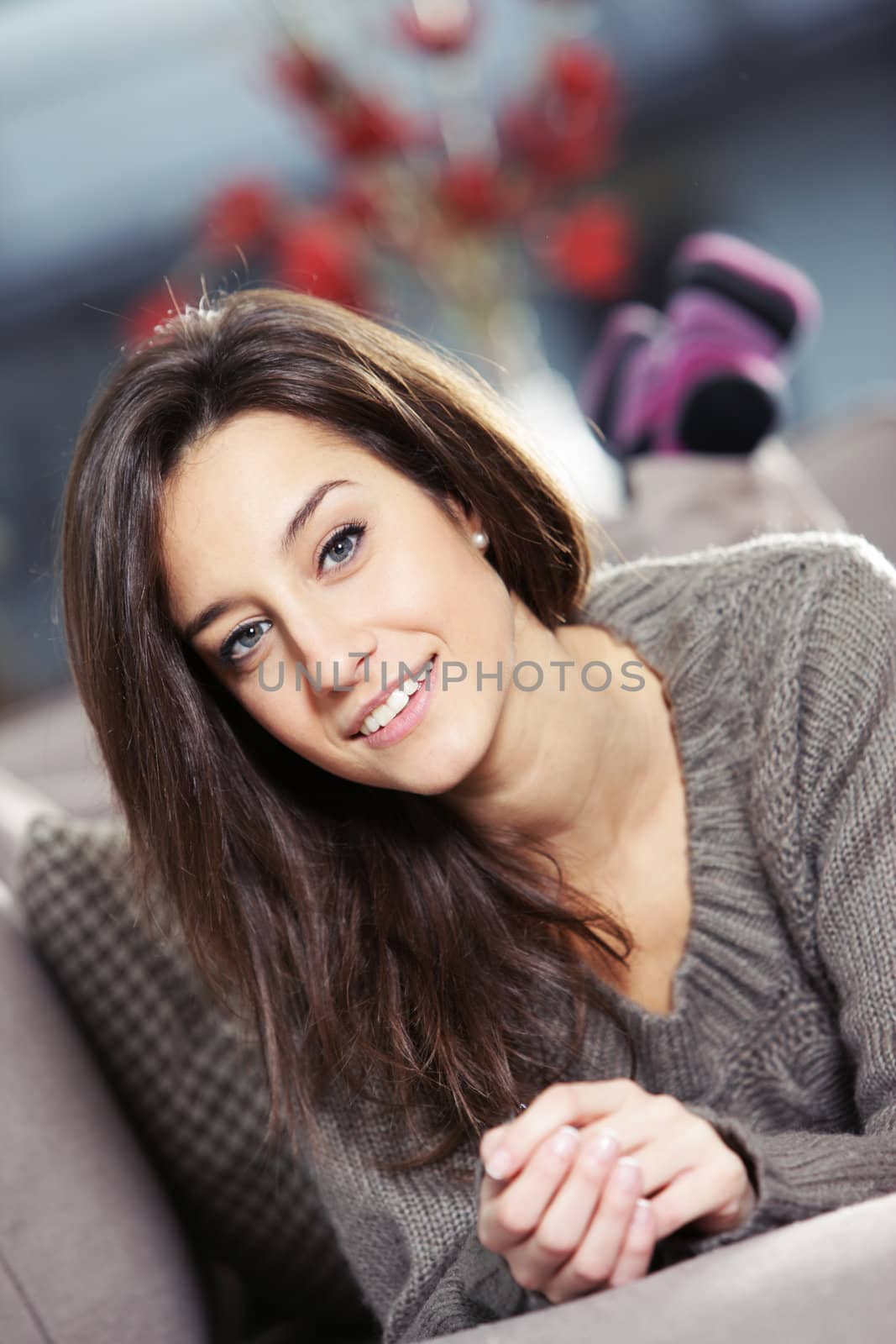 Portrait of a beautiful young woman lying on couch