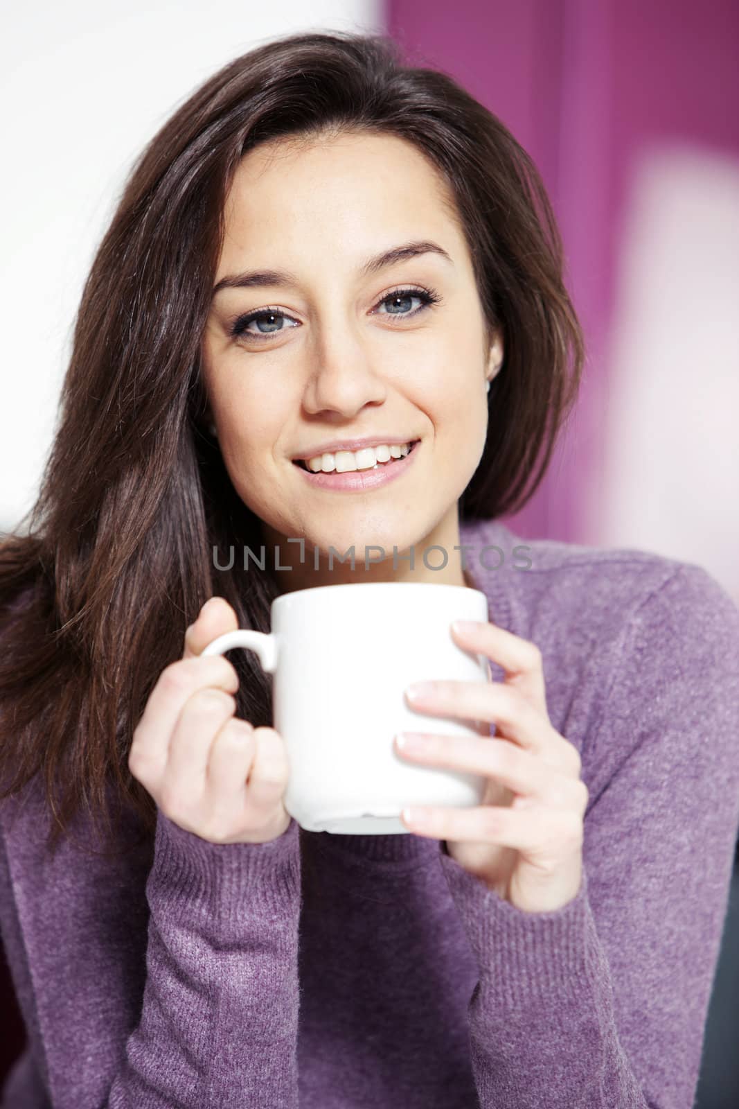 Portrait of a cute young lady with a cup of coffee by stokkete