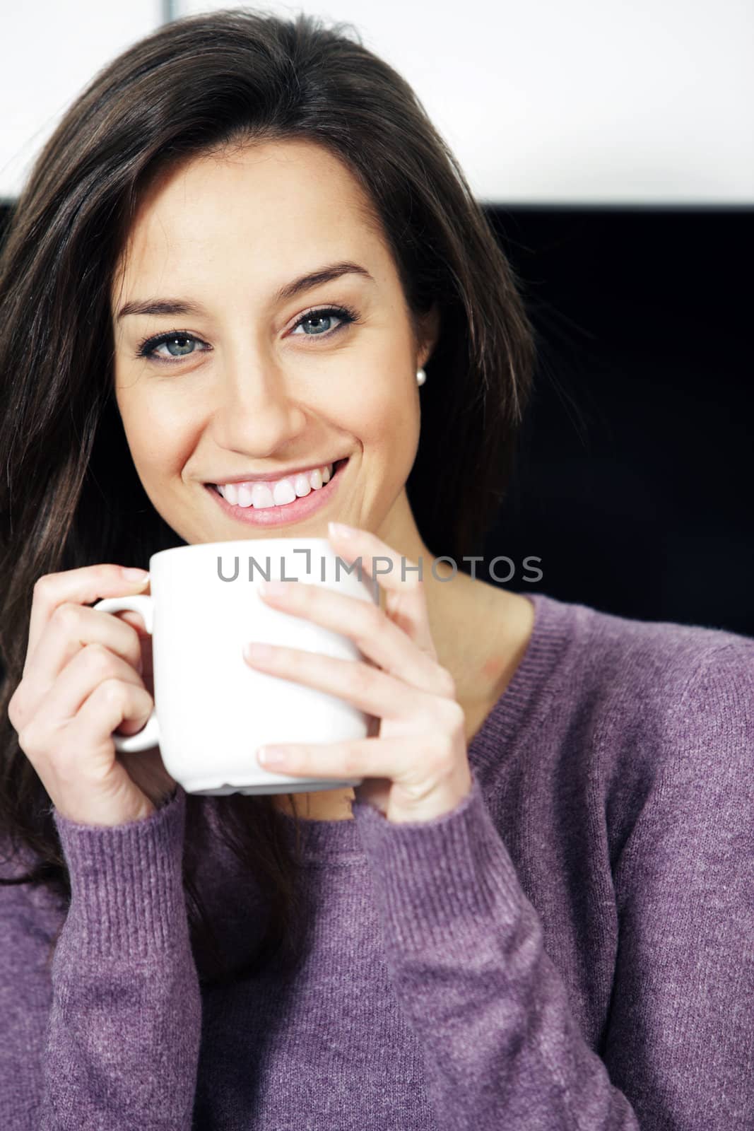 Portrait of a cute young lady with a cup of coffee by stokkete