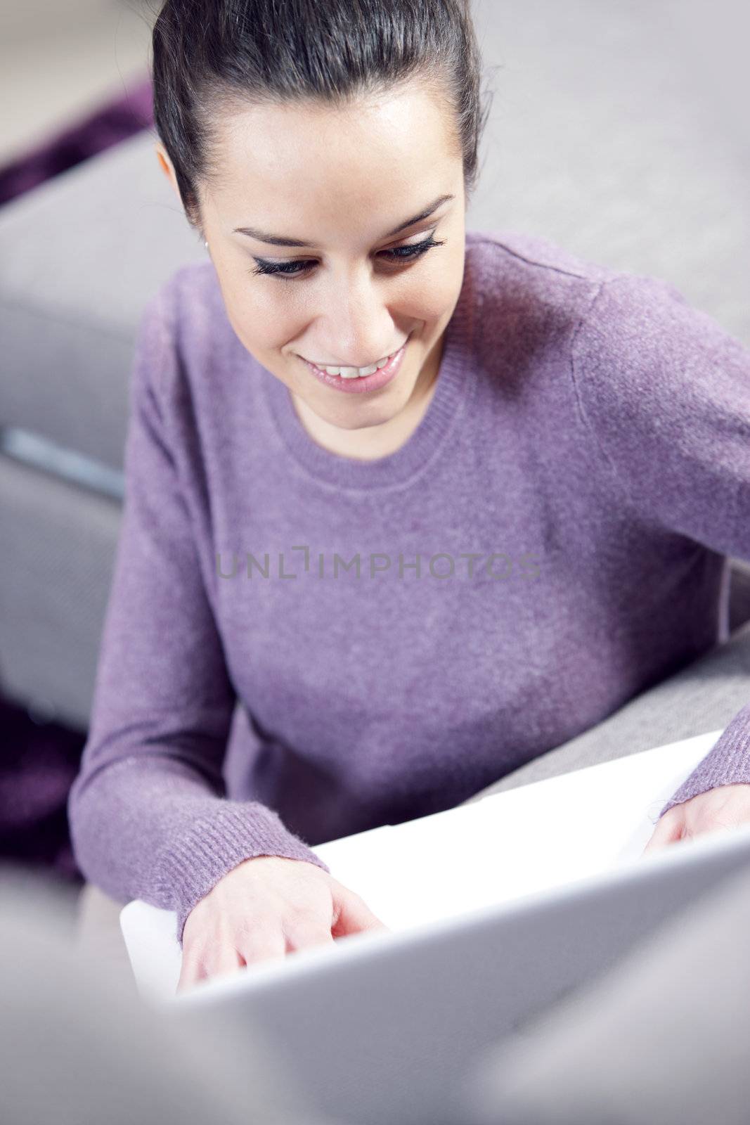 at home: young woman working on her laptop