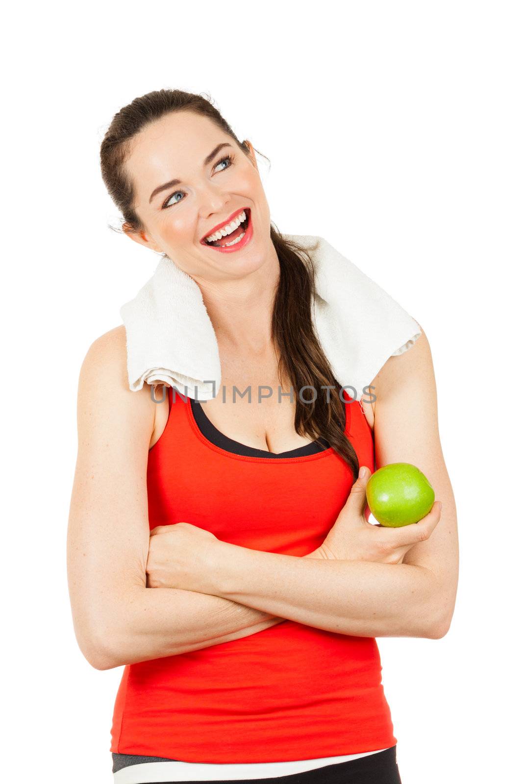 Young smiling fit woman holding an apple and looking at copyspace after exercise. Isolated on white.