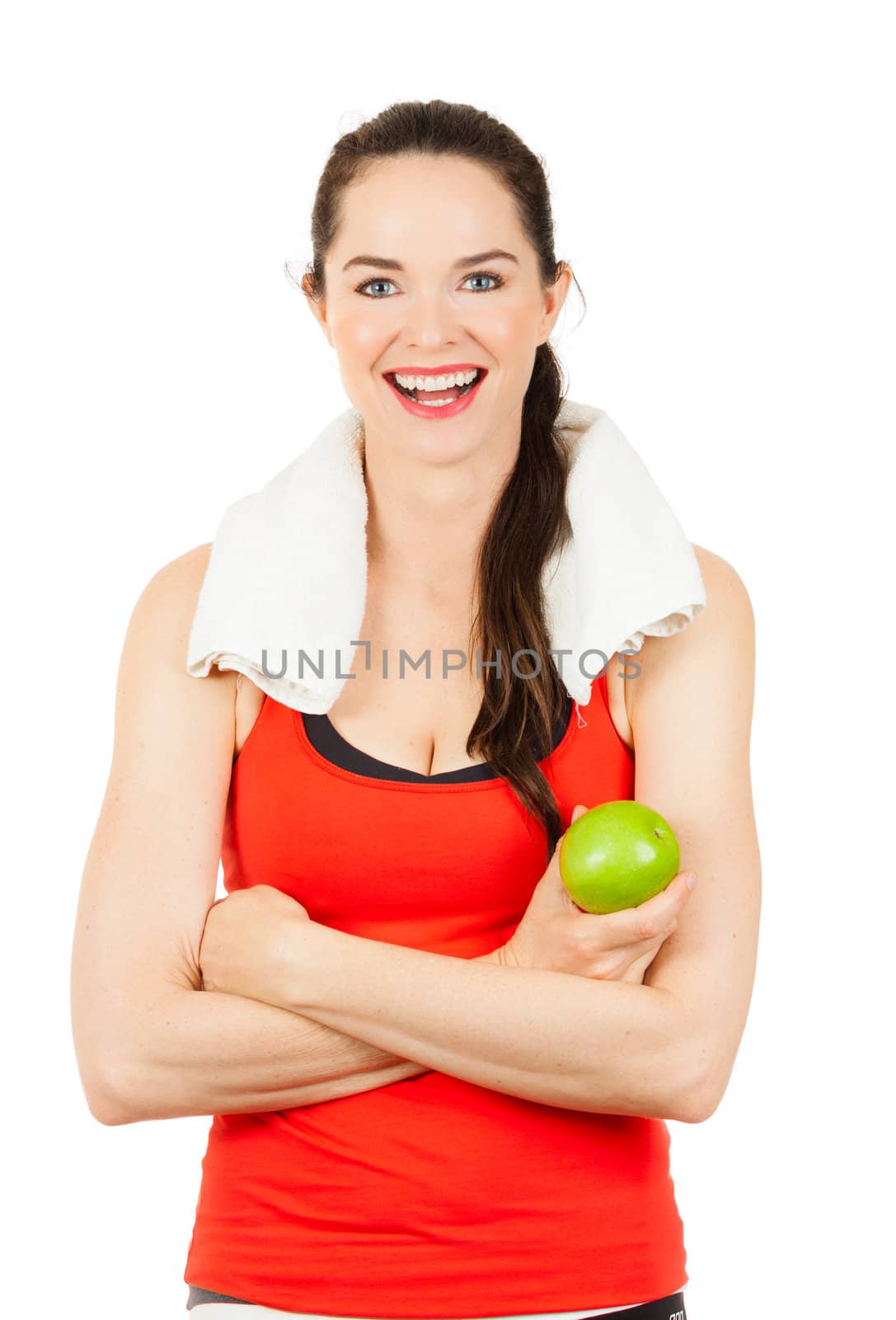 Young happy fit woman holding an apple and smiling after exercise. Isolated on white.