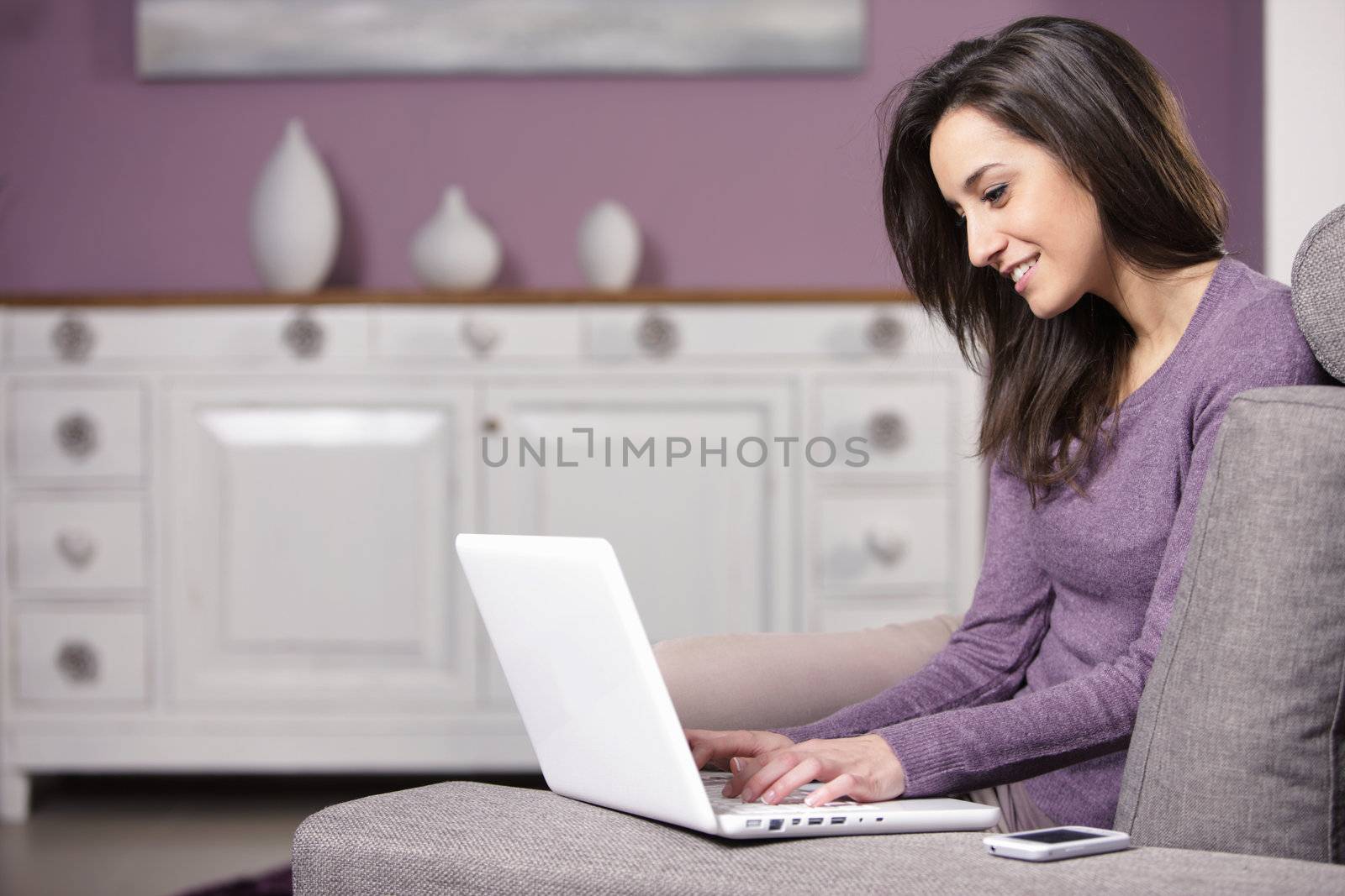 portrait of young woman on the sofa using laptop