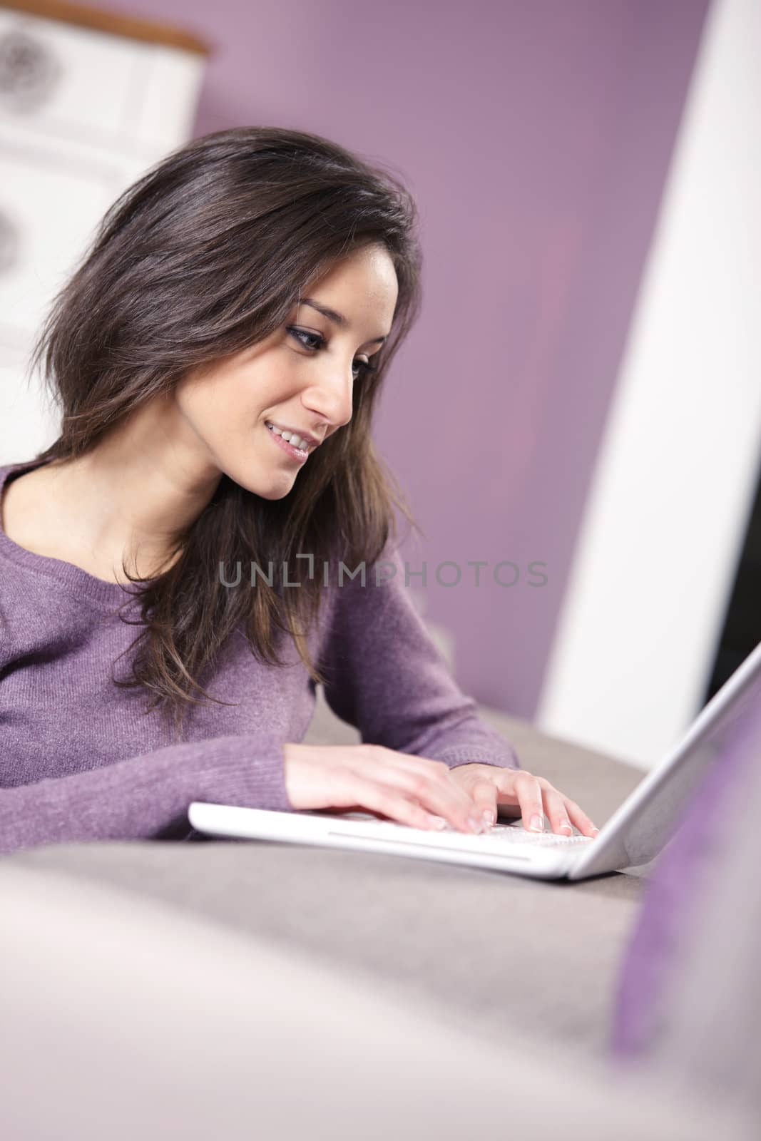 portrait of young woman on the sofa using laptop