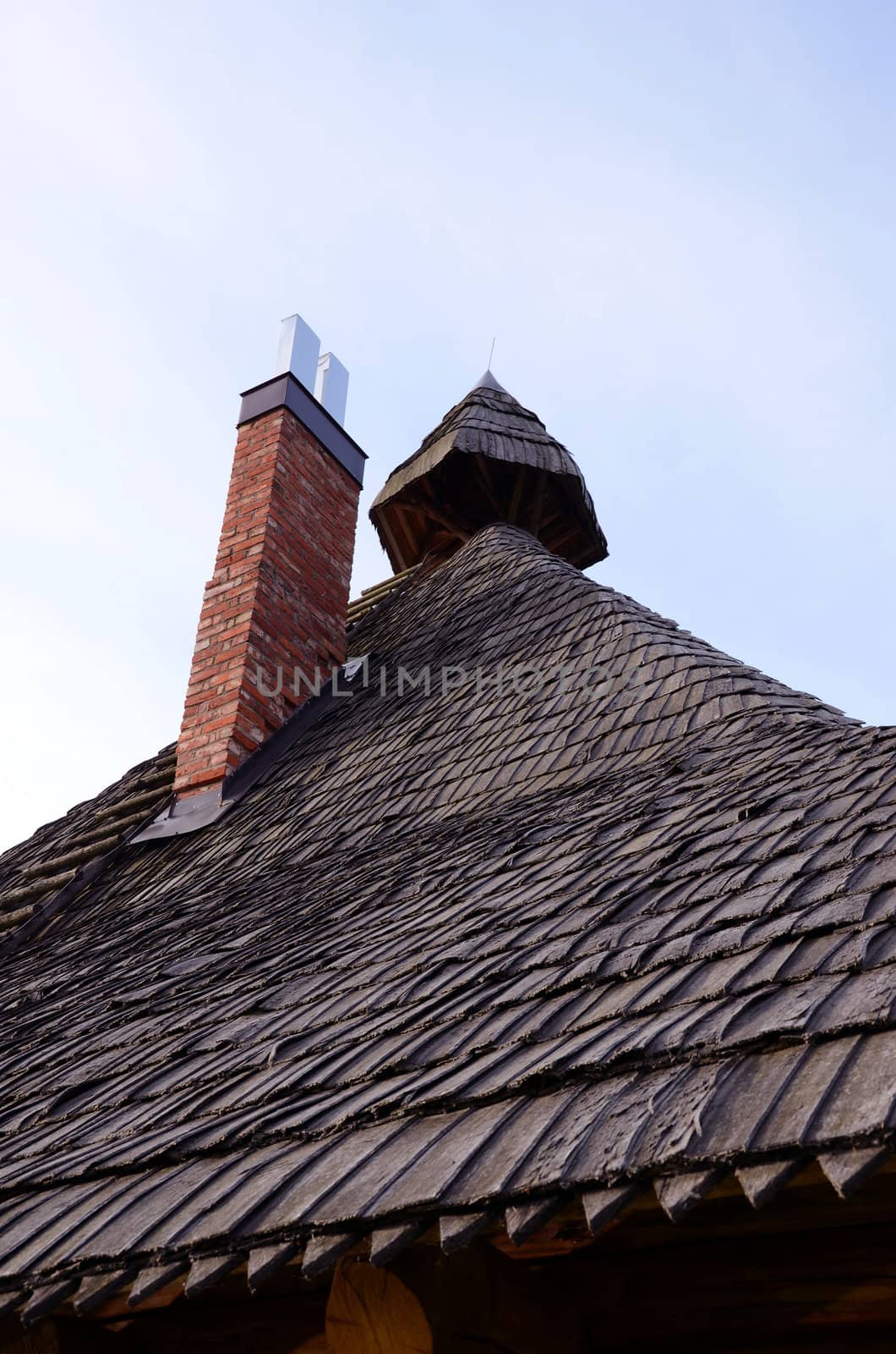 Ancient retro vintage wooden roof and new red brick chimney.