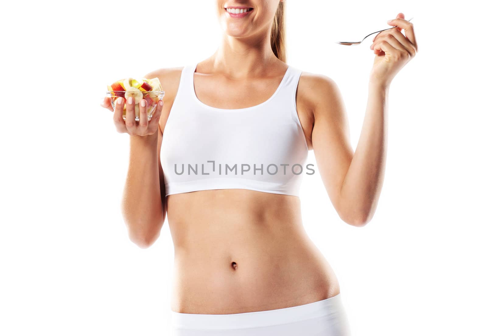 Fit young woman eating fruit salad