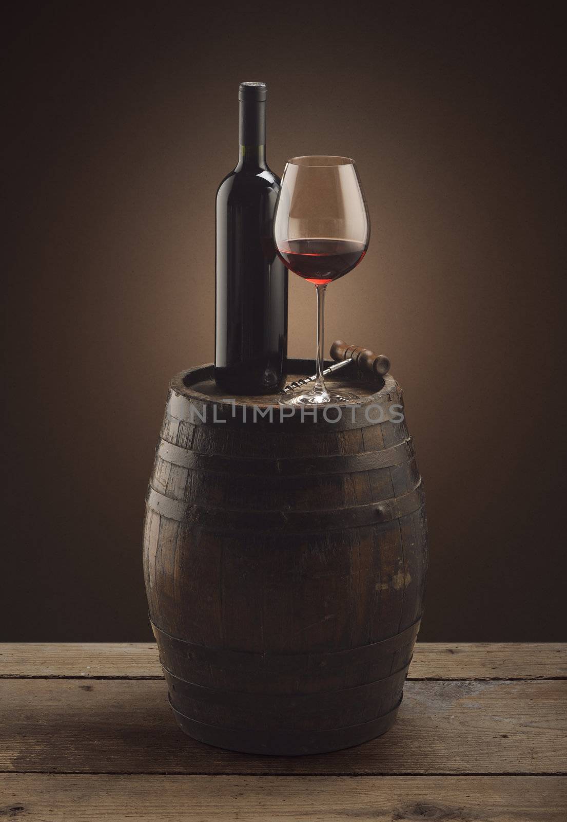 red wine bottle and wine glass on wooden barrel by stokkete