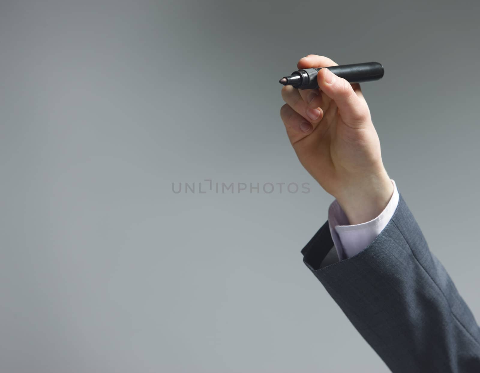 Businessman hand drawing in a whiteboard by stokkete