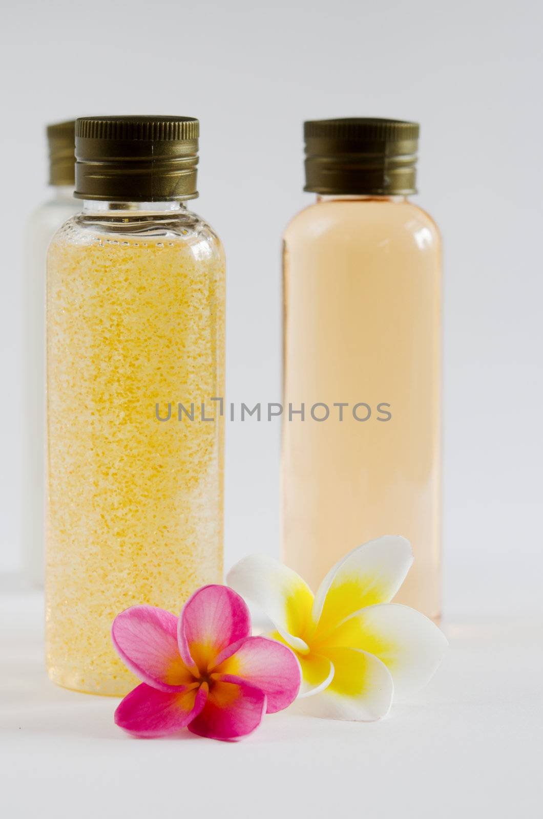 three of bottle cosmetic products and  fresh plumeria .