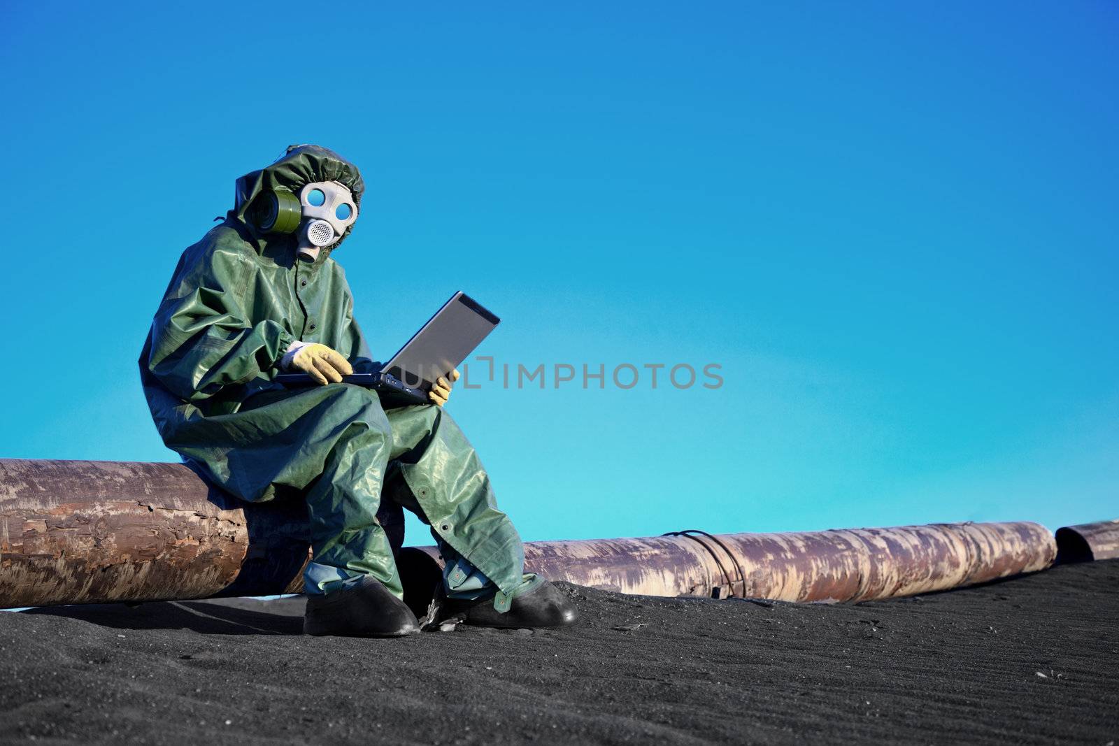 A scientist working with a laptop on a chemically contaminated area