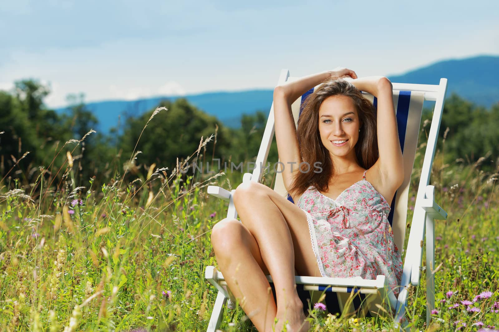 Young beatiful woman relaxing on a field of flowers