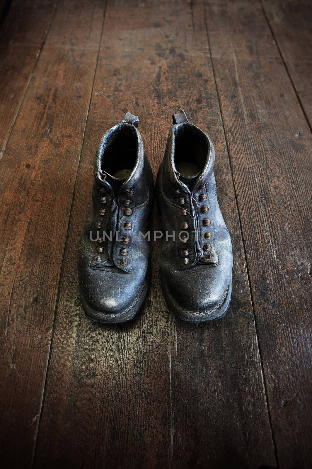 an old pair of leather boots on an old wooden floor