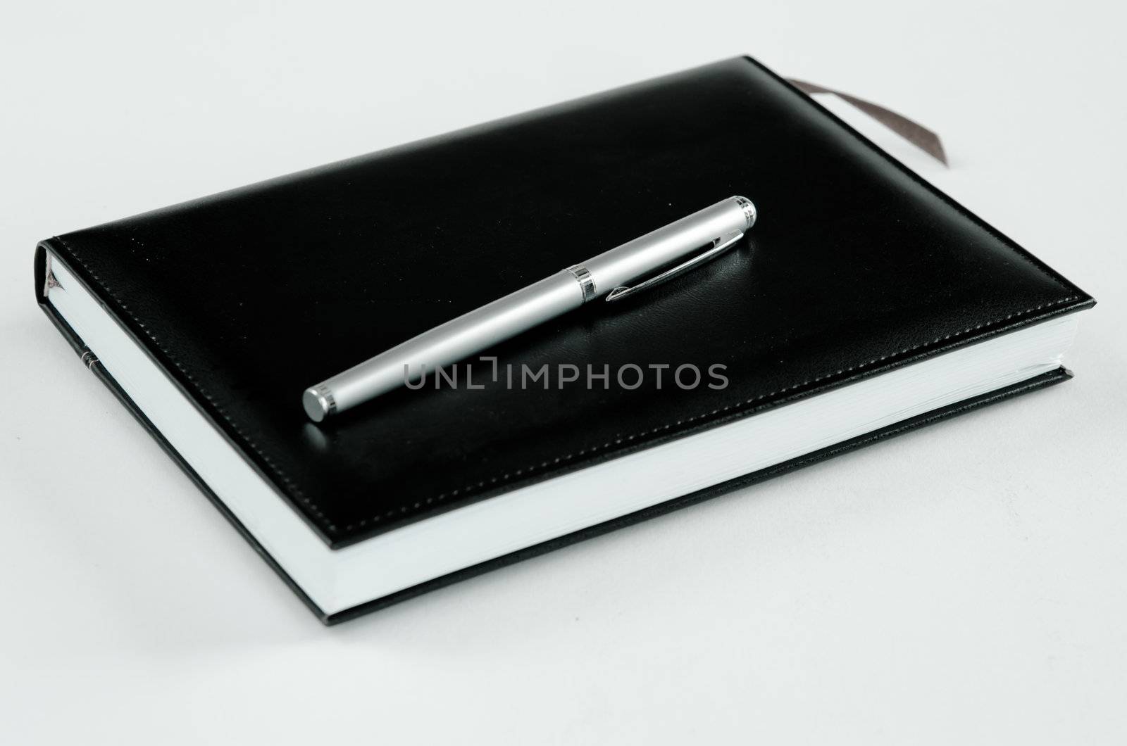 black note book and pen for records on white 