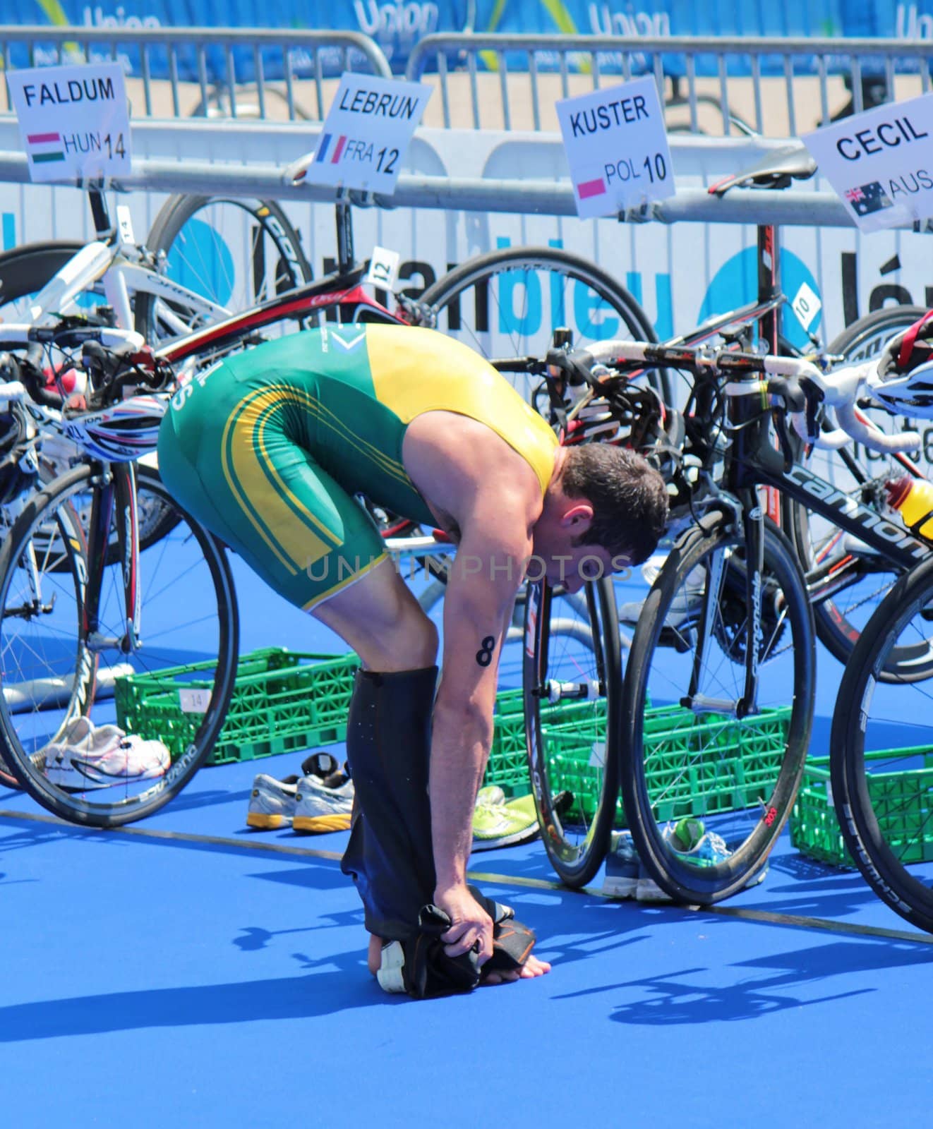 Man athlet removing his clothes to start bicycling at transition space at the International Geneva Triathlon, on July 22, 2012 in Geneva, Switzerland.