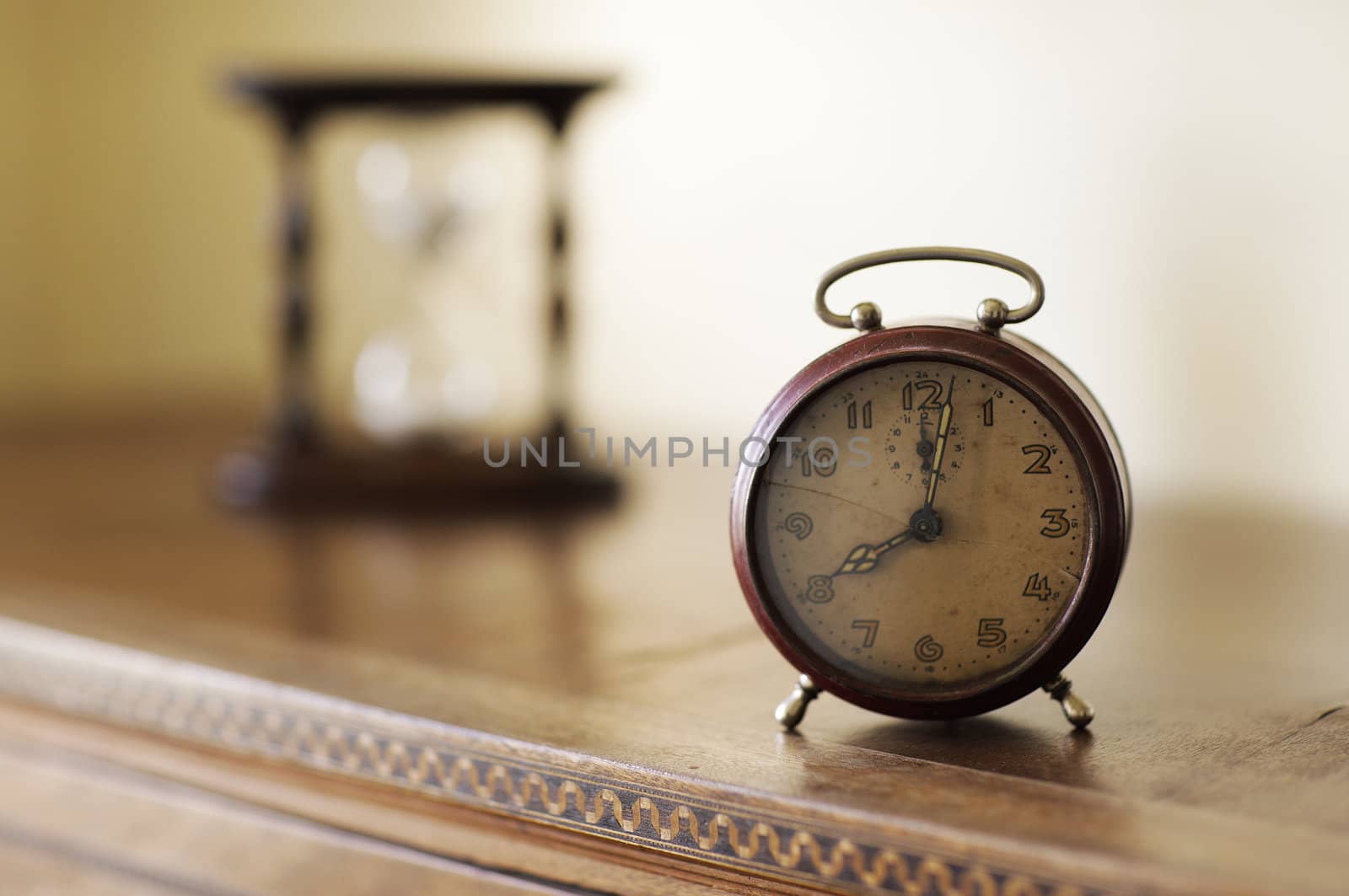 old alarm clock with hourglass on background, copy space