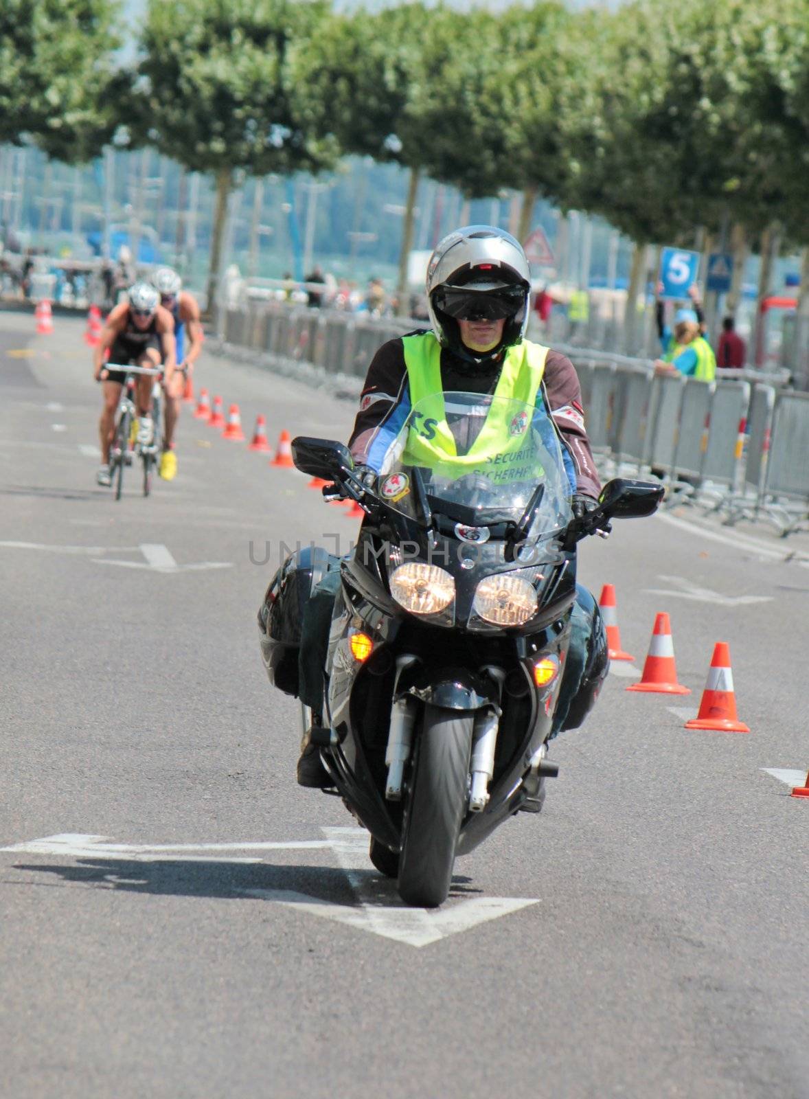 Security motorbike running before unidentified males cyclists at the 2012 International Geneva Triathlon, Switzerland.