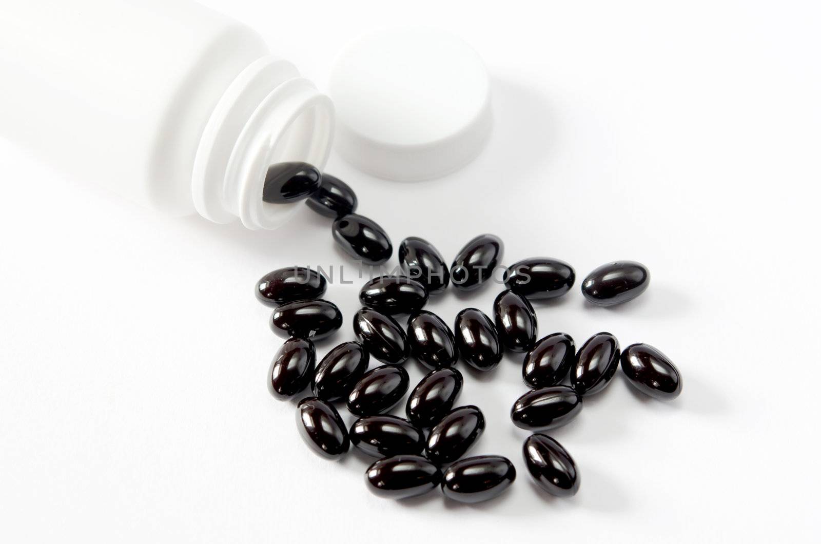 Pills spilling out of  pill bottle on white background