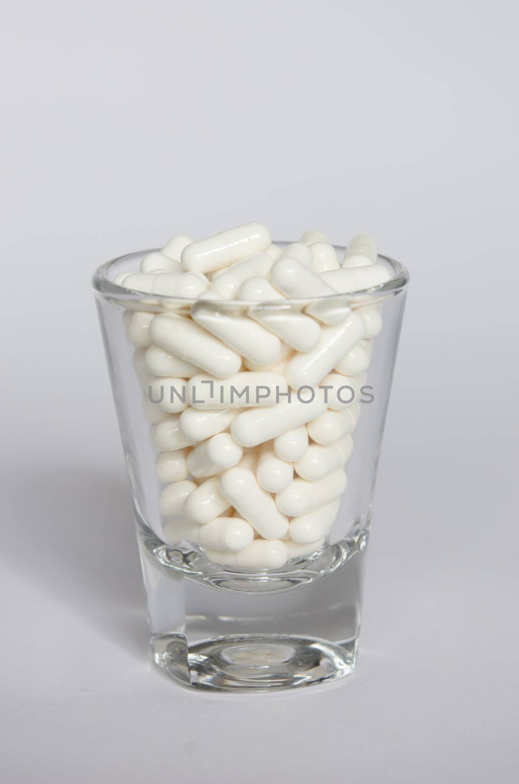 full of white medicines  in glass 