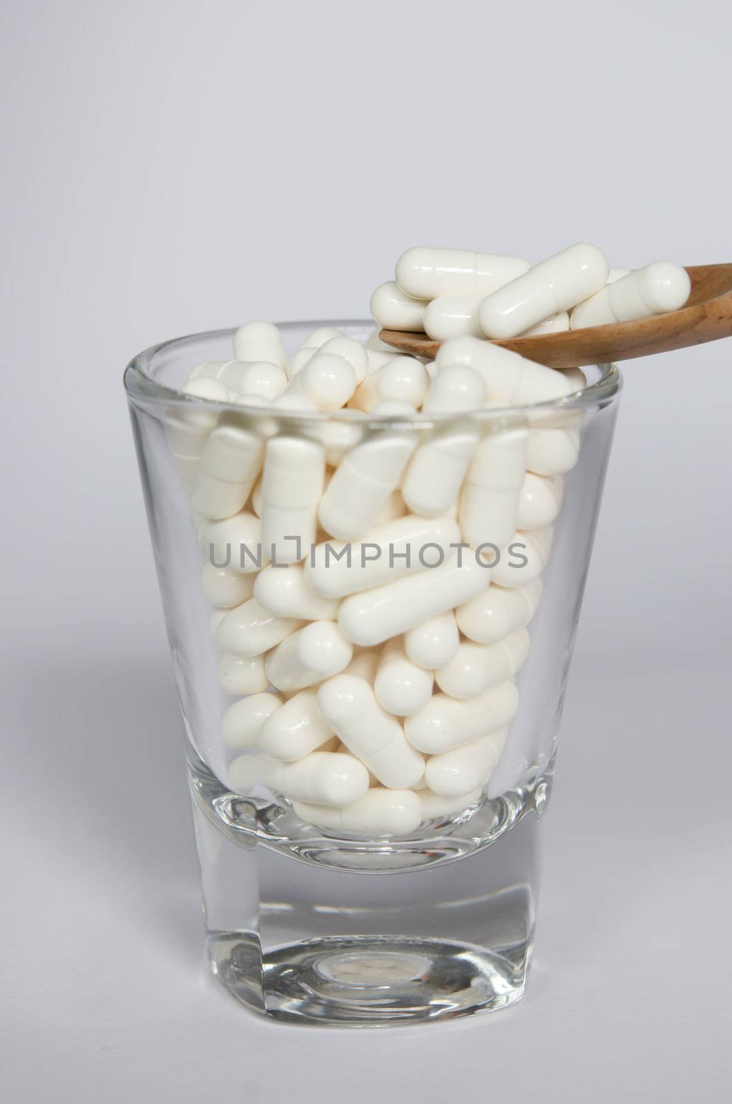 white pills  in glass  and pills on spoon 