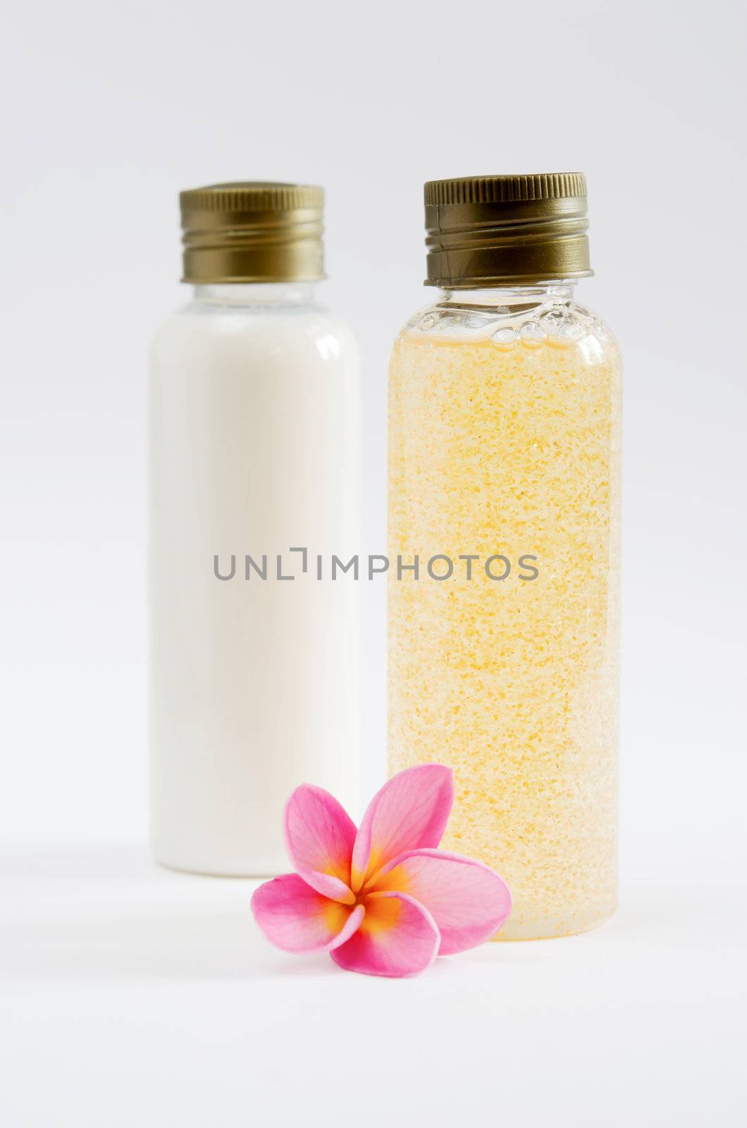 two of bottle and  fresh plumeria on white background