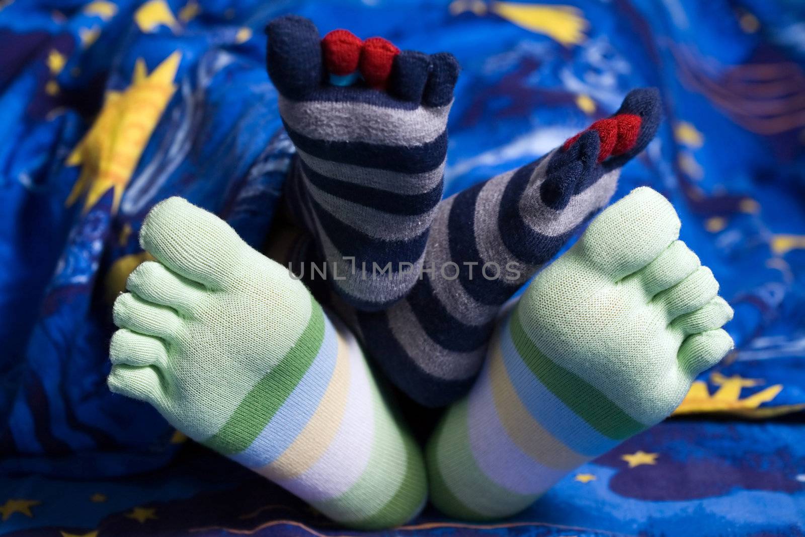 Stock photo: an image of two pairs of funny feet in striped socks