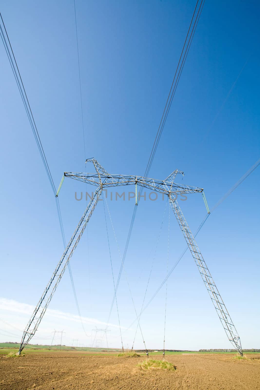 High voltage pylons on the background  of  blue  cloudless  sky

