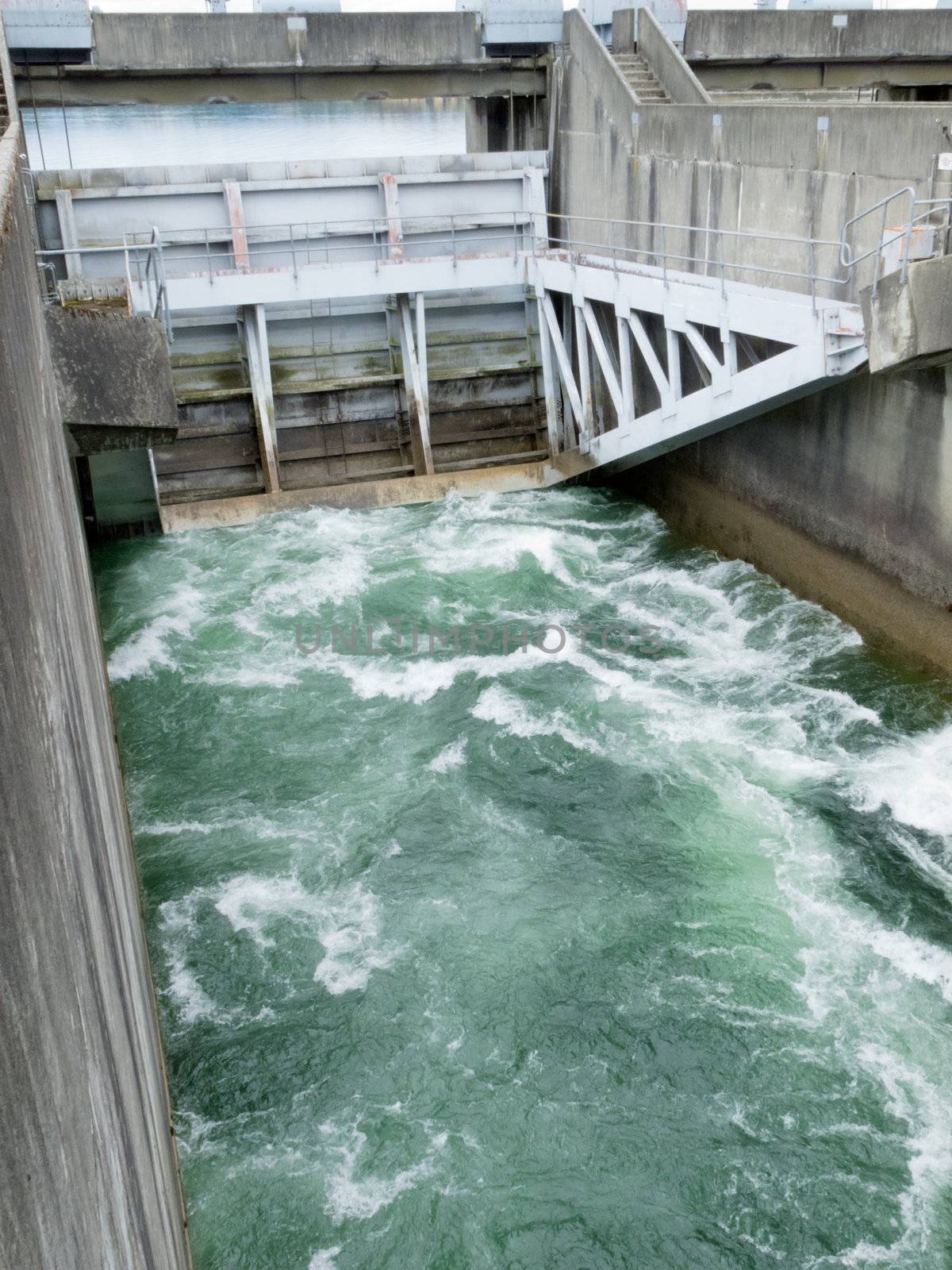 Hydro control structure weir with flow passing underneath causing a violent turbulence discharge of white water