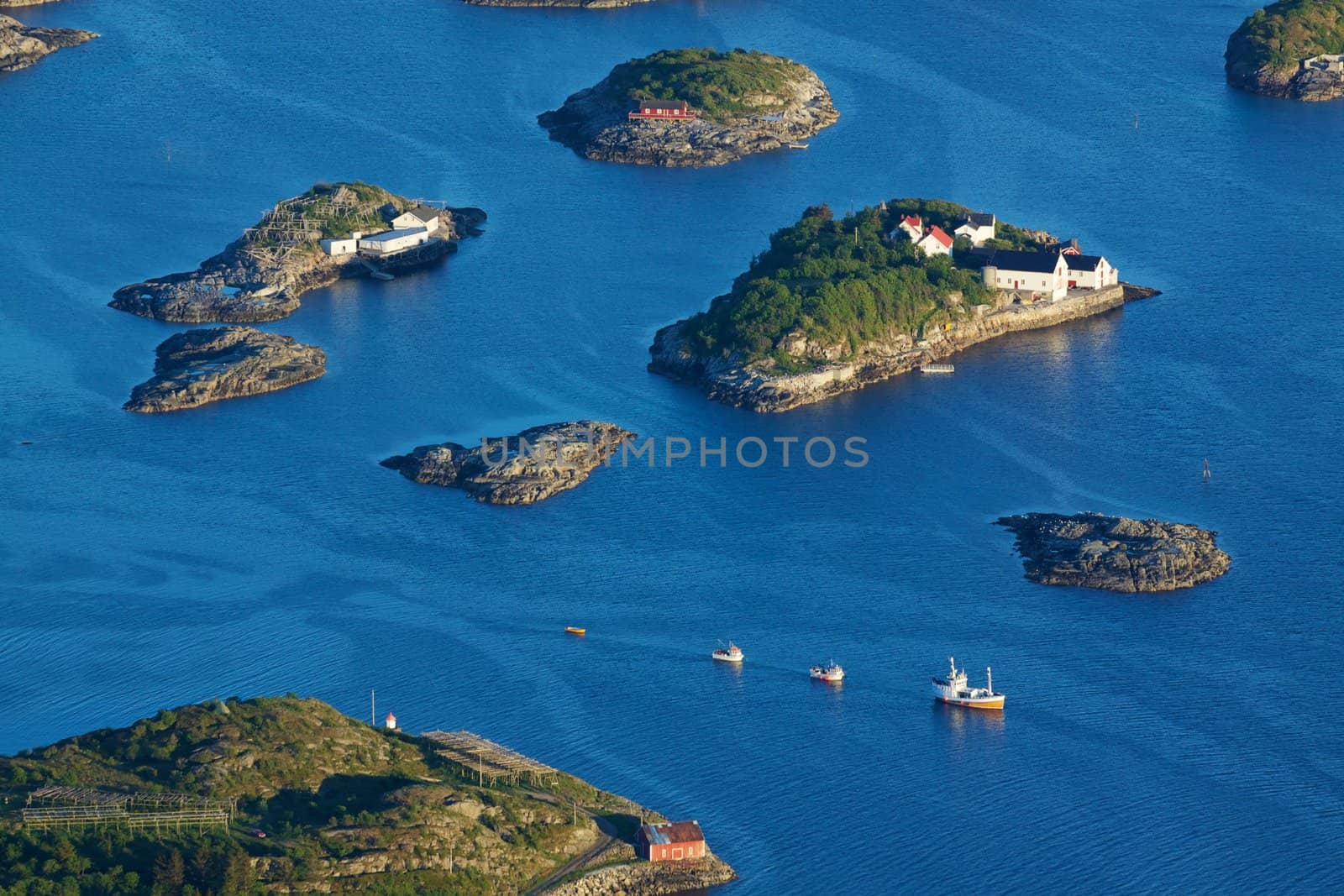 Bird eye view of fishing boats sailing between scenic islets near Henningsvaer on Lofoten islands in Norway