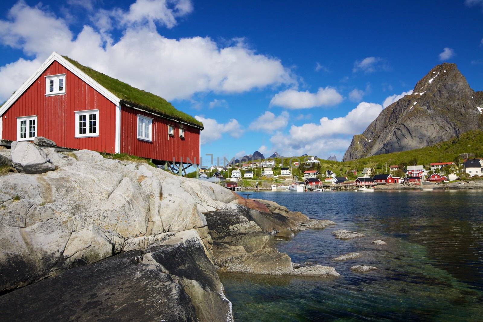 Typical red rorbu hut with sod roof in town of Reine on Lofoten islands in Norway