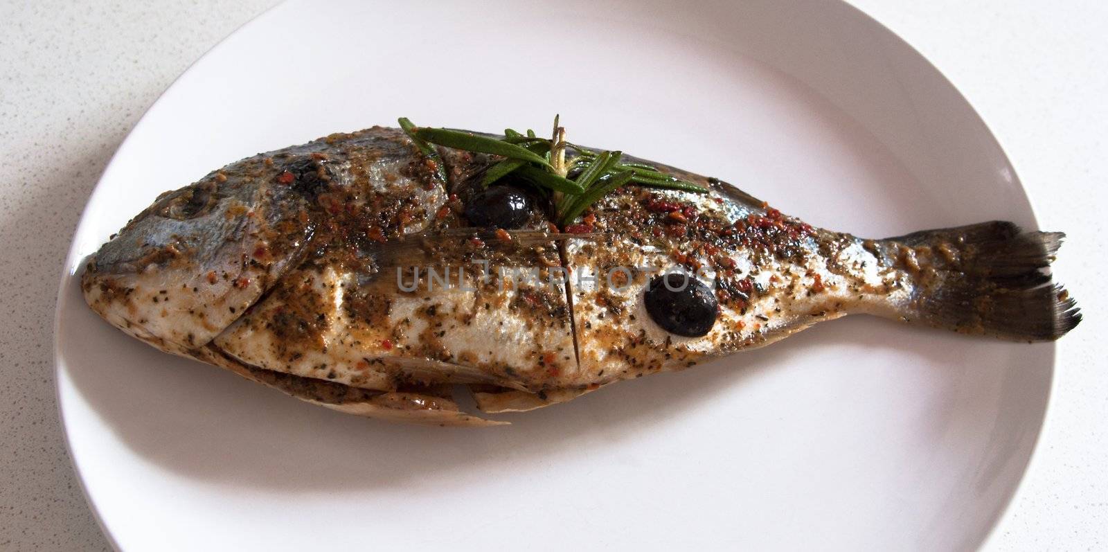 Gilthead seabream nicely marinated waiting on a plate ready for barbecue
