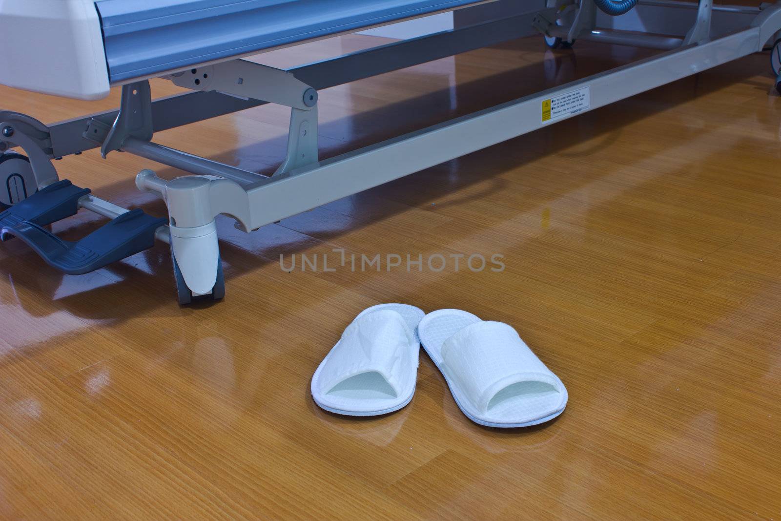 Stock Photo - A pair of white slippers on a Brown background