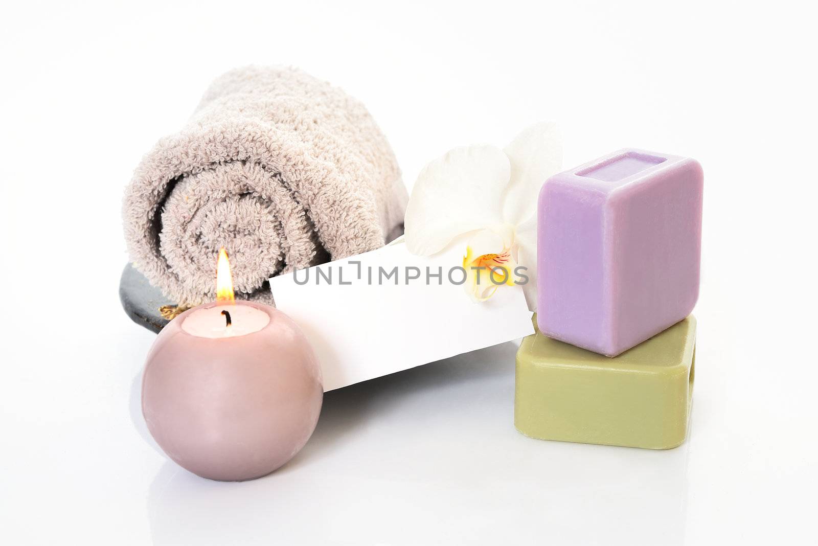 Spa and wellness setting with natural soap, candles and towel. Beige dayspa