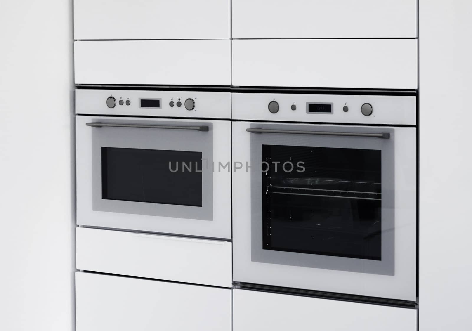 Modern ovens integrated in contemporary white kitchen