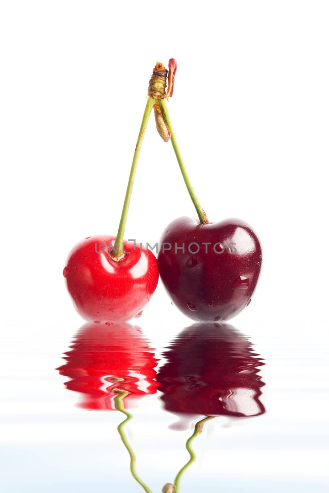 An image of two red berries in a water.