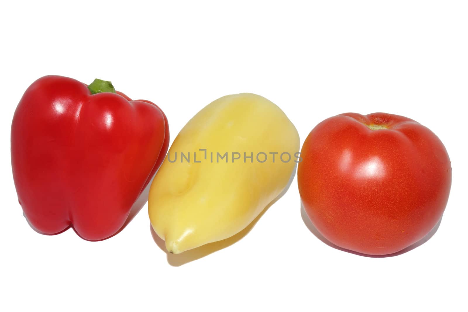 Red sweet pepper, yellow sweet pepper and red tomato on a white background