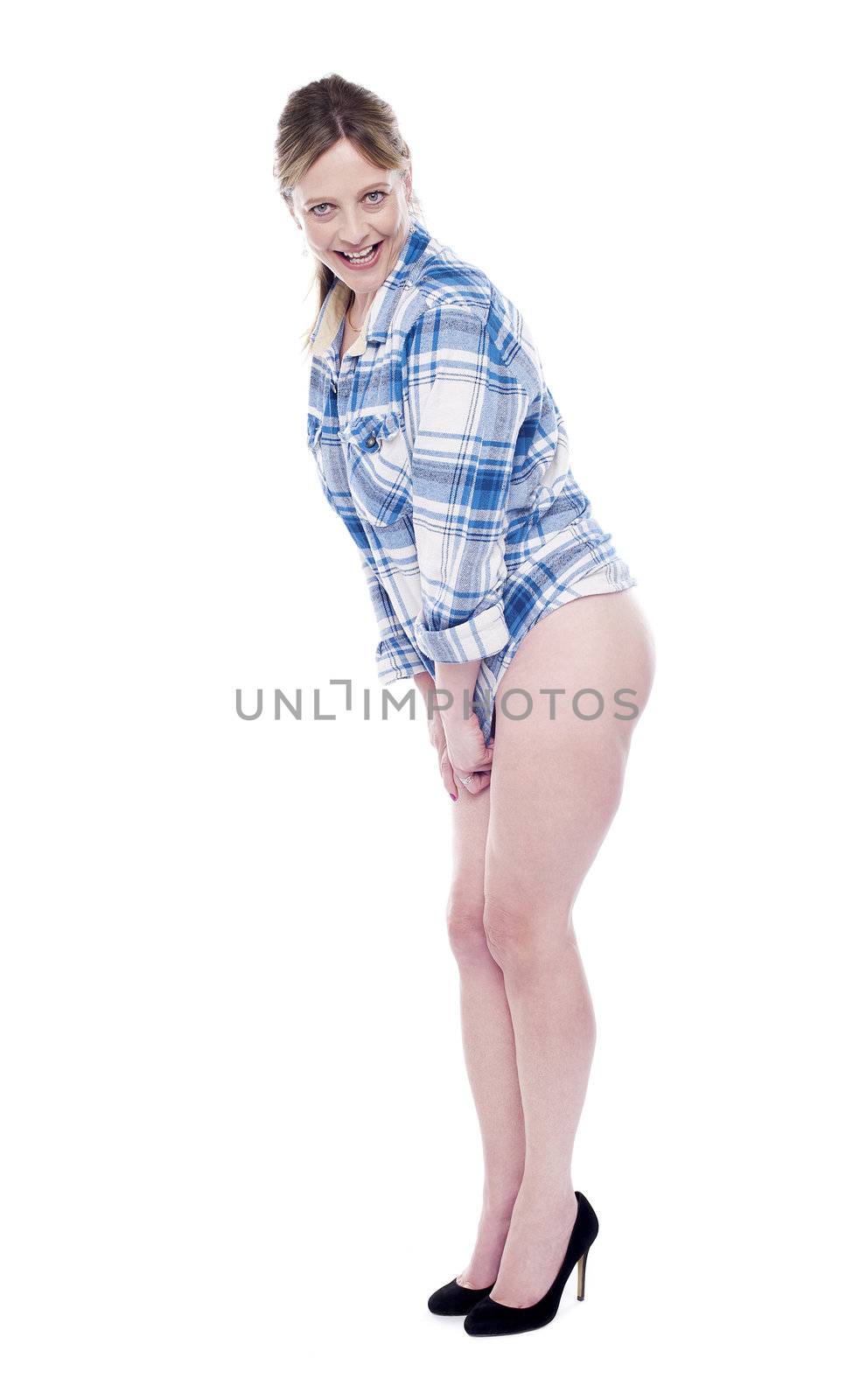 Fashion pose of beautiful woman in shirt. Hiding her body parts by stretching shirt