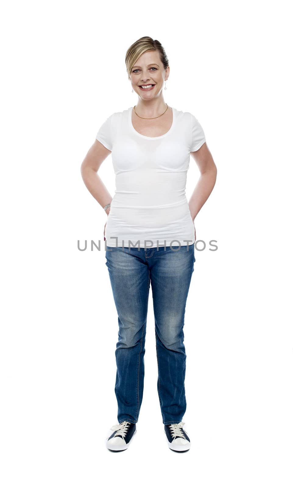 Casual trendy female with hands in jeans pocket, full length portrait