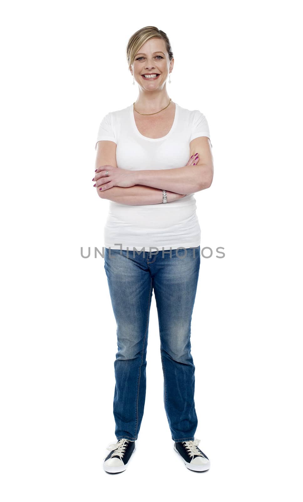 Casual aged woman posing with crossed arms standing over white background