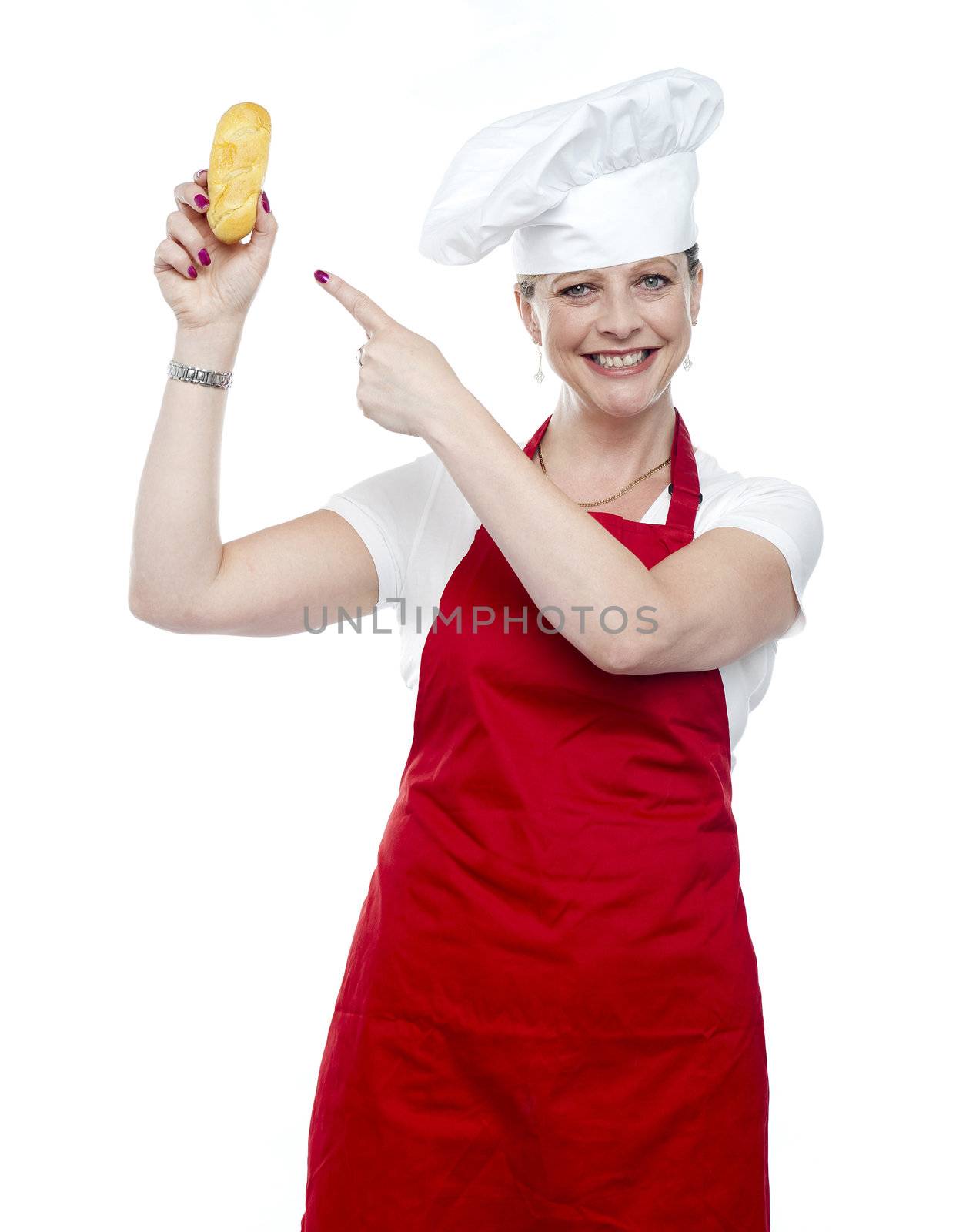 Experienced female cook pointing at bread isolated against white background