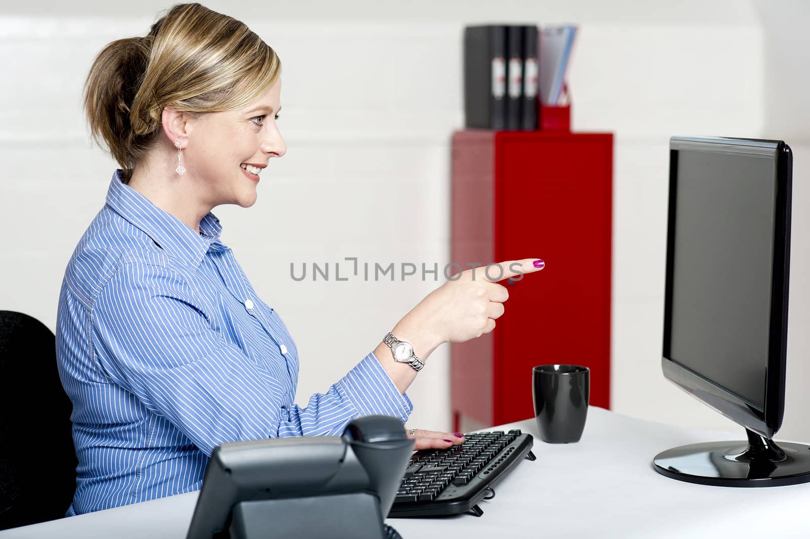 Businesswoman pointing at computer screen seated in office
