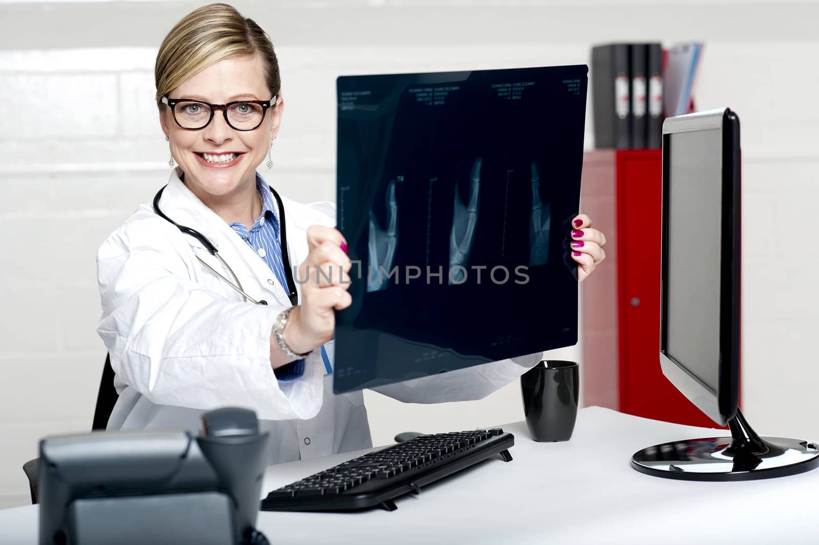 Experienced female physician holding x-ray report wearing glasses