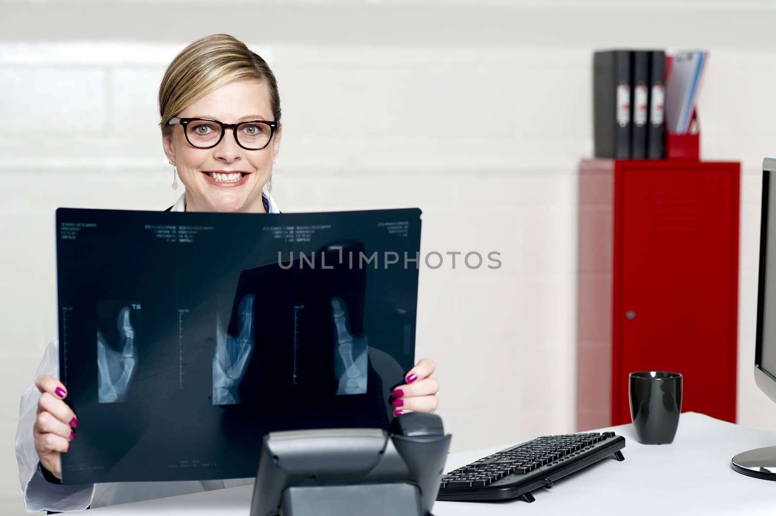 Female surgeon showing x-ray reports to camera. Siting in her chamber