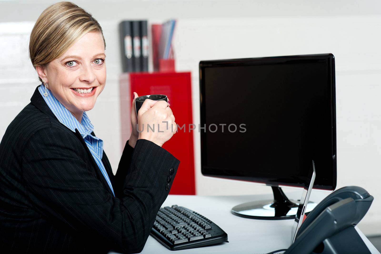 Corporate lady enjoying coffee during break sitting in office