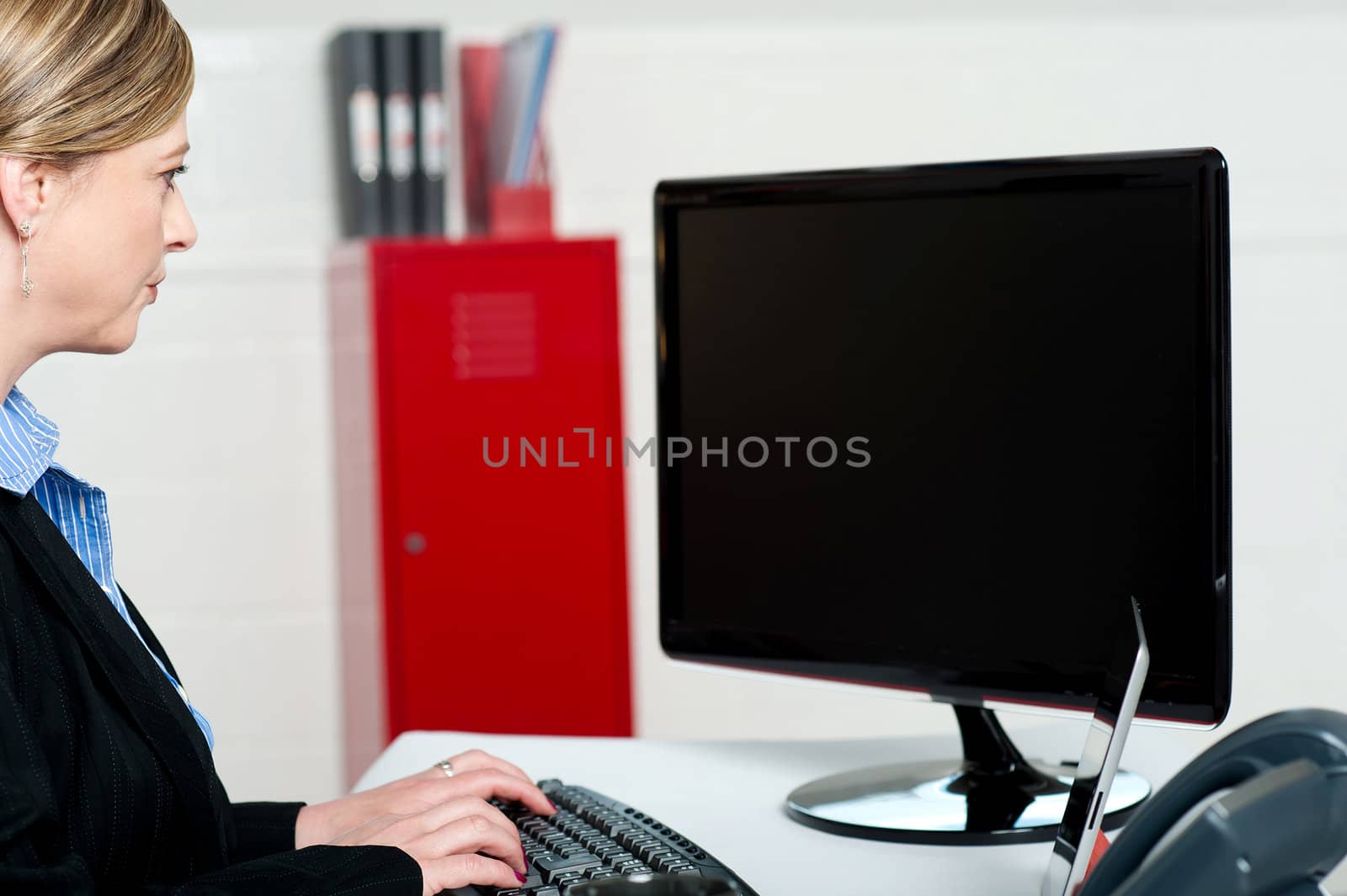 Female executive typing and looking at lcd screen. Working on computer