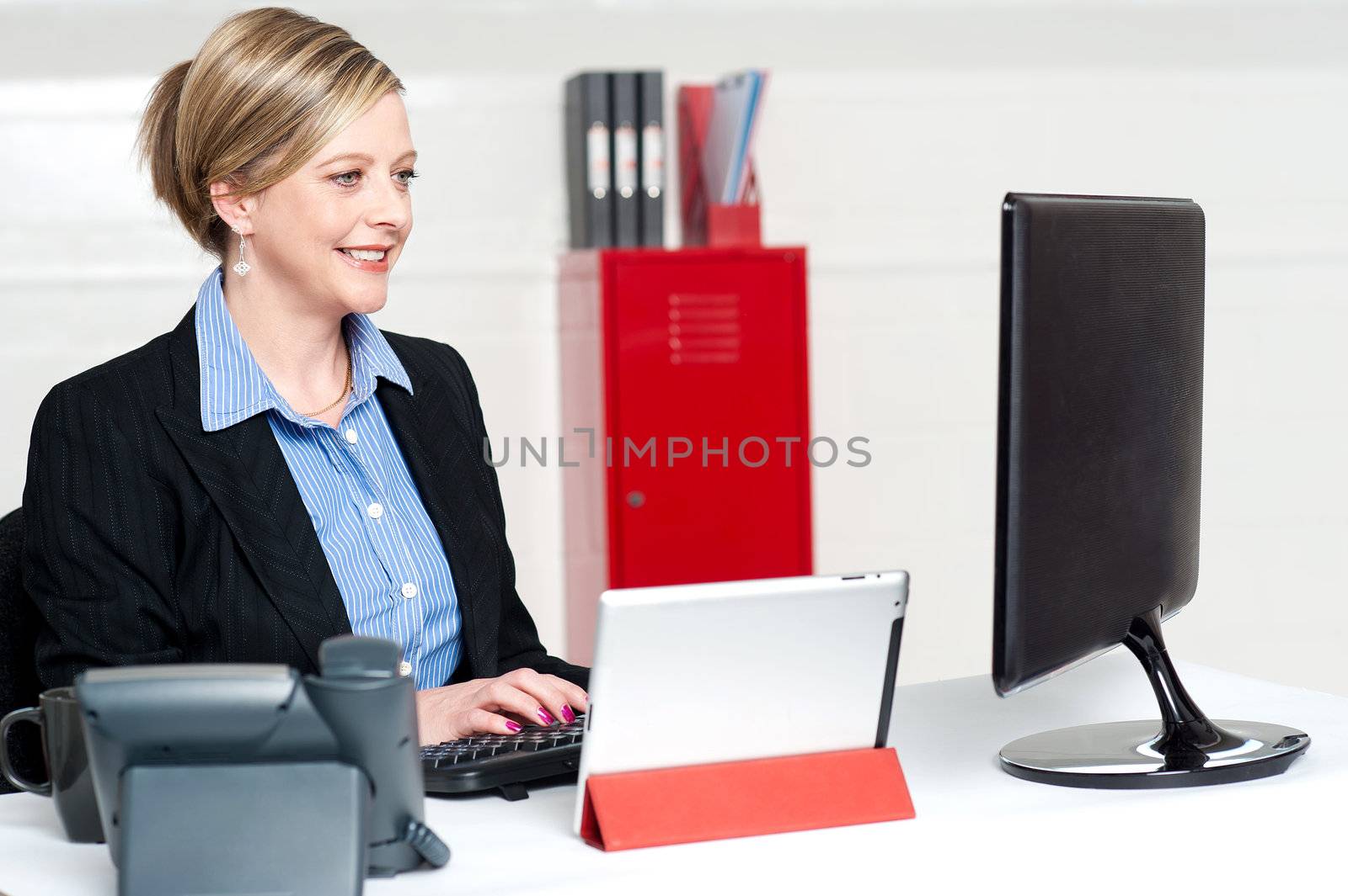 Confident businesswoman working in office. Concentration on computer screen while typing doucment