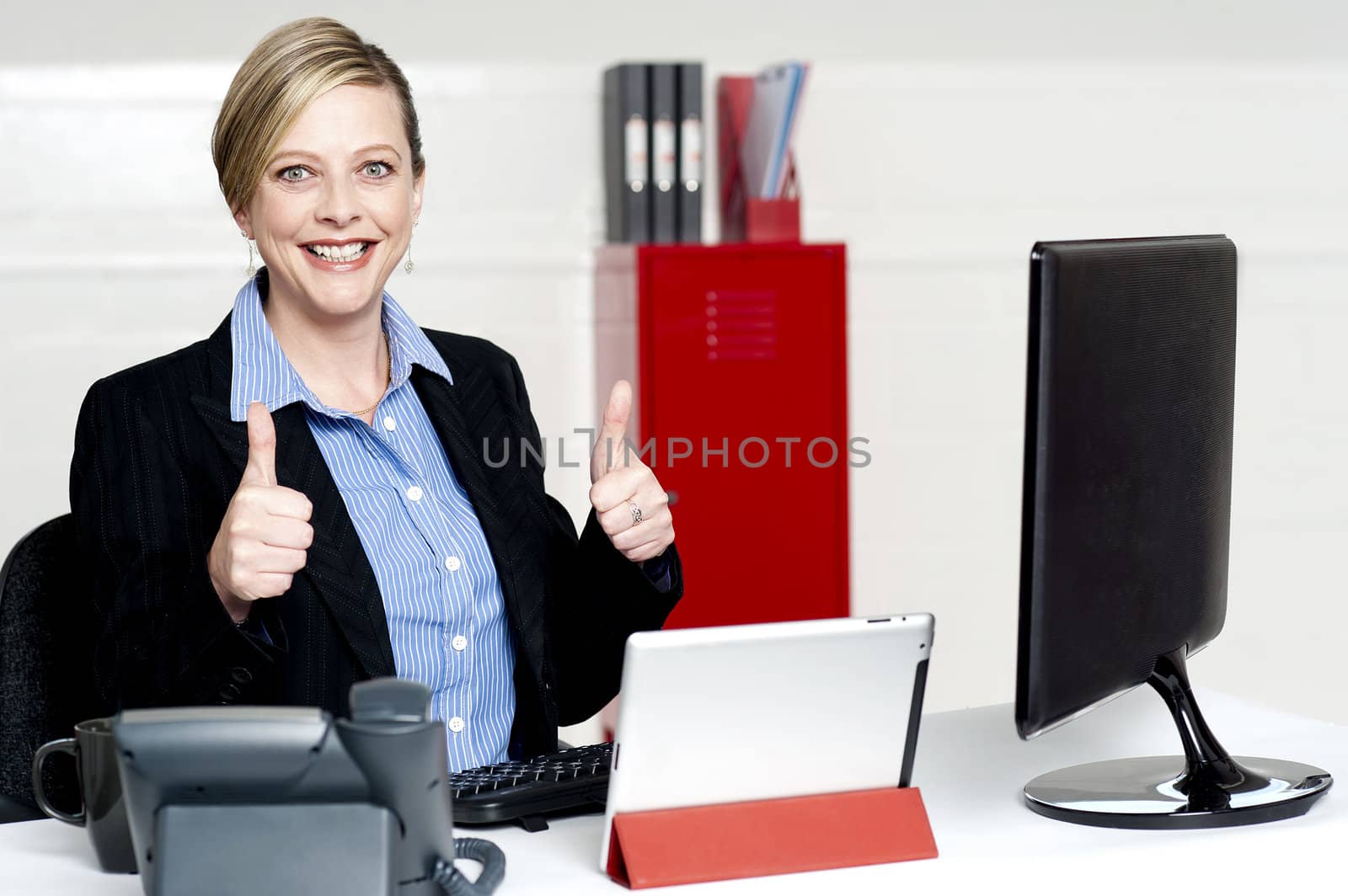 Senior businesswoman gesturing thumbs up working actively in office