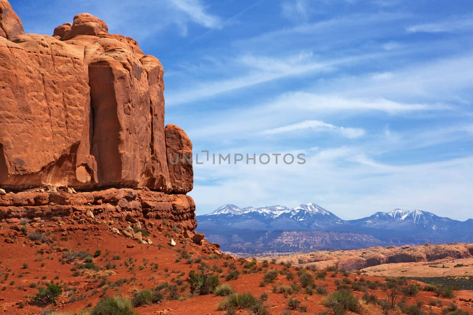 Red rock canyons and snow covered mountains with hazy blue sky