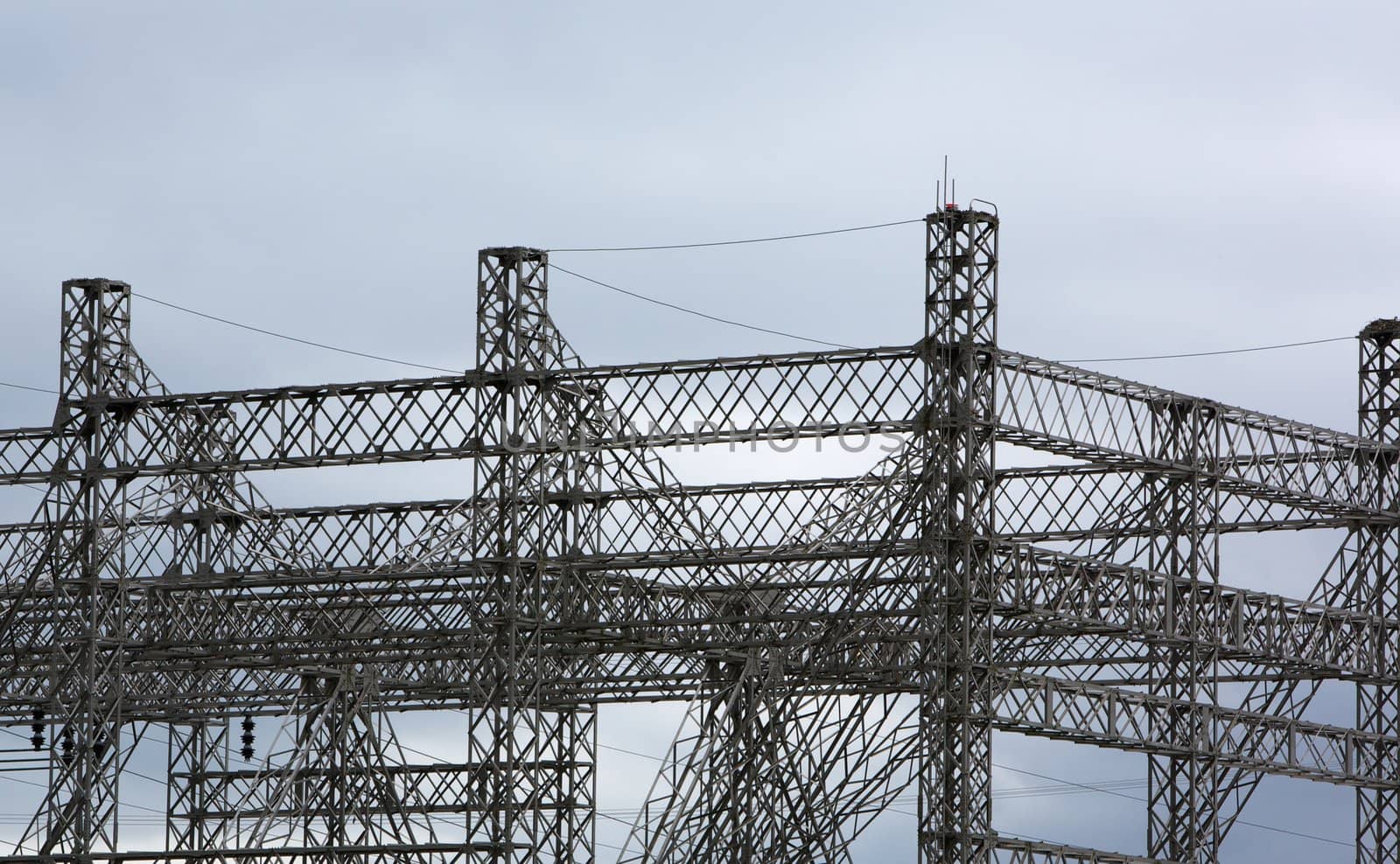 Complex steel structure of electrical power grid against cloudy sky