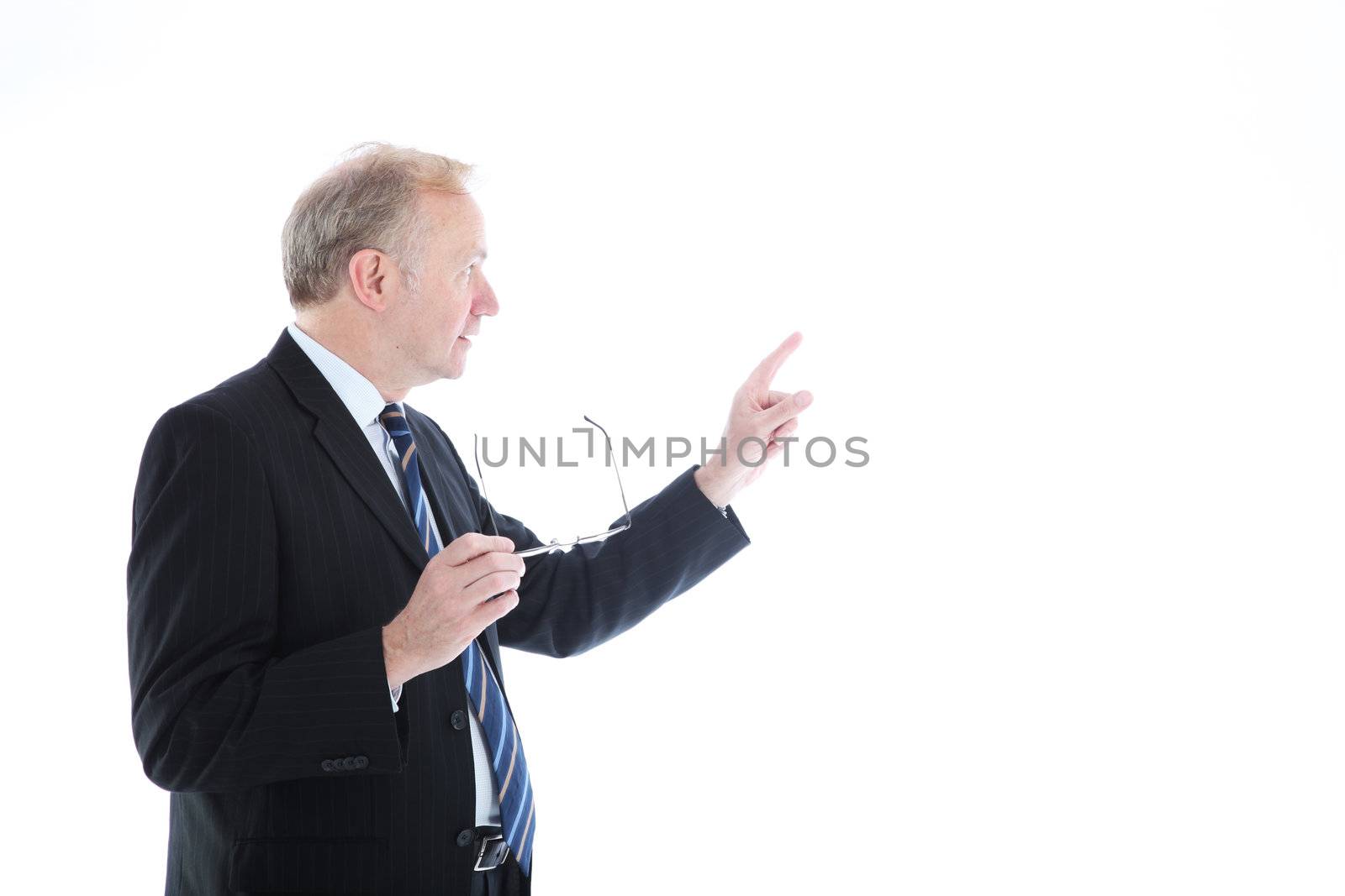 Businessman looking back away from the camera and pointing with his index finger to blank copyspace